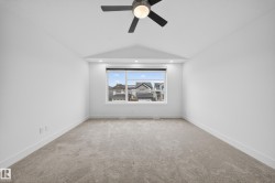 Spacious room with a large window, plush carpet flooring, recessed lighting, and a contemporary ceiling fan - 