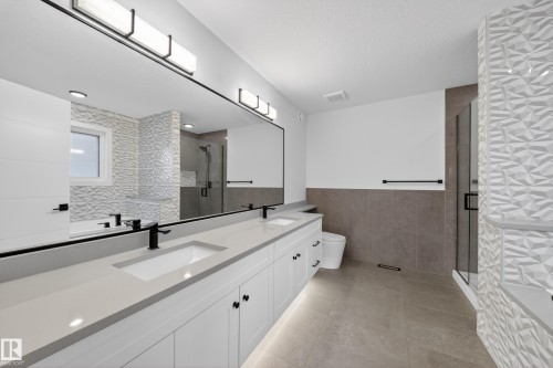 Double vanity featuring quartz countertops and matte black fixtures - 7414 Chivers Crescent Sw, Edmonton, AB - Indoor Photo Showing Bathroom