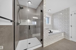 Modern bathroom featuring a tiled shower with a clear glass enclosure and matte black fixtures - 