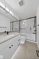 Contemporary bathroom featuring a white vanity with matte black hardware, integrated sink, and light gray countertop - 
