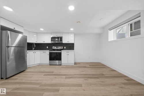 Contemporary kitchen featuring white cabinetry and stainless steel appliances - 7414 Chivers Crescent Sw, Edmonton, AB - Indoor Photo Showing Kitchen