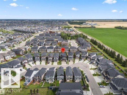 Residential community featuring a mix of modern homes, paved streets, and a greenbelt border - 7414 Chivers Crescent Sw, Edmonton, AB - Outdoor With View