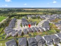Aerial perspective showcasing a residential neighborhood with detached homes, surrounded by green spaces and agricultural fields - 7414 Chivers Crescent Sw, Edmonton, AB  - Outdoor With View 