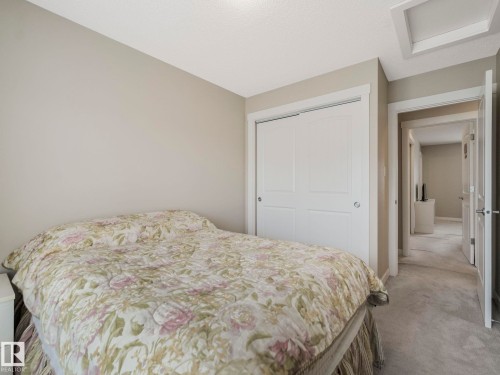 Bedroom featuring neutral wall colors, carpet flooring, and a white sliding closet door - 96 8315 180 Avenue, Edmonton, AB - Indoor Photo Showing Bedroom