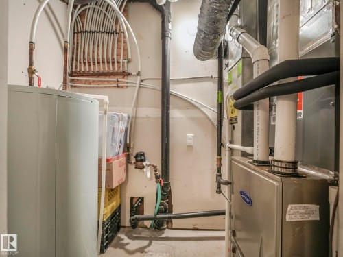 Utility room featuring a water heater and furnace with exposed plumbing and ductwork - 96 8315 180 Avenue, Edmonton, AB - Indoor Photo Showing Basement