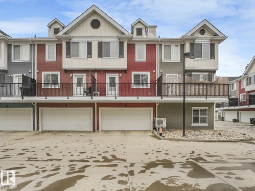 Multi-level townhome exterior featuring varied siding colors and multiple balconies with dark iron railings - 96 8315 180 Avenue, Edmonton, AB - Outdoor With Balcony With Facade