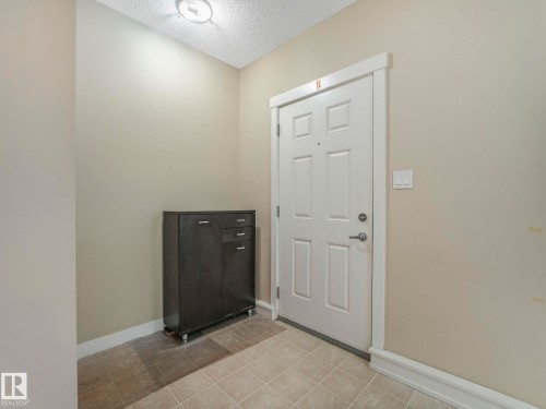 Entryway featuring a paneled door with white trim, a flush-mount ceiling light, and neutral wall paint - 96 8315 180 Avenue, Edmonton, AB - Indoor Photo Showing Other Room