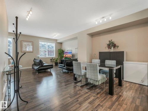 Open-concept living and dining area featuring wood-finish flooring, neutral wall tones, and recessed lighting - 96 8315 180 Avenue, Edmonton, AB - Indoor Photo Showing Dining Room
