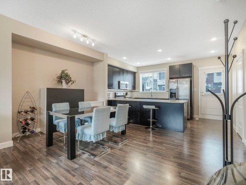 Open-concept living space featuring wood-finish flooring, recessed lighting, and a modern kitchen - 96 8315 180 Avenue, Edmonton, AB - Indoor Photo Showing Dining Room