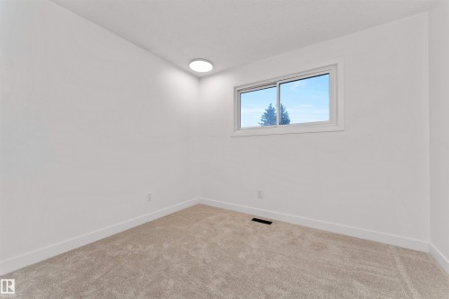 Neutral paint palette, new carpeting, baseboard trim, recessed lighting, and a sliding window - 3208 130 Avenue, Edmonton, AB - Indoor Photo Showing Other Room