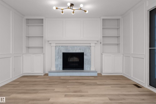 Fireplace featuring light blue mosaic tile surround, white mantel, and a dark hearth - 3208 130 Avenue, Edmonton, AB - Indoor With Fireplace