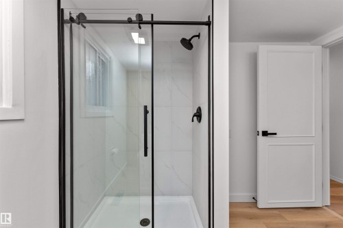 Frameless glass shower enclosure with matte black hardware - 3208 130 Avenue, Edmonton, AB - Indoor Photo Showing Bathroom