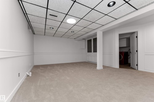 Spacious carpeted room featuring a grid drop ceiling with recessed lighting and a central circular light fixture - 3208 130 Avenue, Edmonton, AB - Indoor Photo Showing Other Room