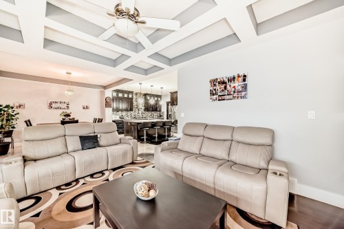 Living area featuring a coffered ceiling with a ceiling fan, recessed lighting, and wood-finish flooring - 69 Caragana Way, Fort Saskatchewan, AB 