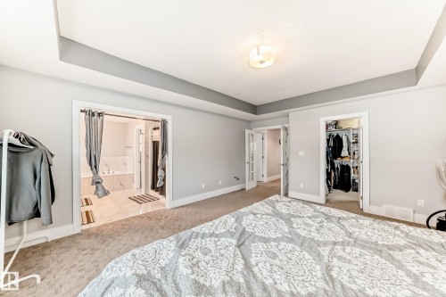 Carpeted room featuring a tray ceiling with recessed lighting - 69 Caragana Way, Fort Saskatchewan, AB 