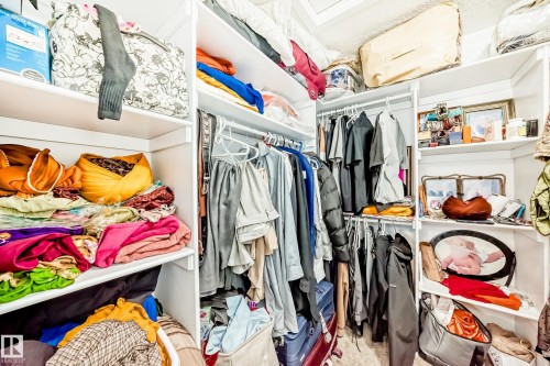 Built-in white shelving system with multiple storage levels and clothing rods - 69 Caragana Way, Fort Saskatchewan, AB 