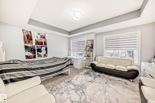 Spacious room featuring a tray ceiling, recessed lighting, and dual windows with blinds - 69 Caragana Way, Fort Saskatchewan, AB 