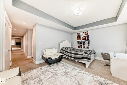 Carpeted room featuring a tray ceiling with a contrasting accent color and recessed lighting - 69 Caragana Way, Fort Saskatchewan, AB 