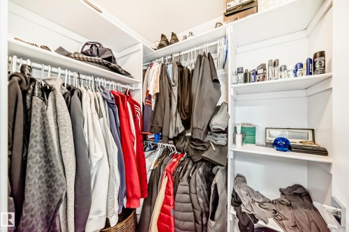 Custom closet system featuring multiple hanging rods and integrated shelving - 69 Caragana Way, Fort Saskatchewan, AB 