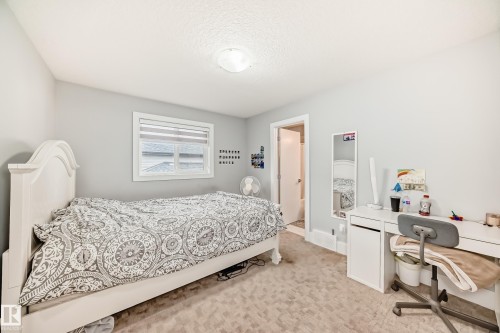 Carpeted room featuring light gray walls, a window with horizontal blinds, and a white interior door - 69 Caragana Way, Fort Saskatchewan, AB 