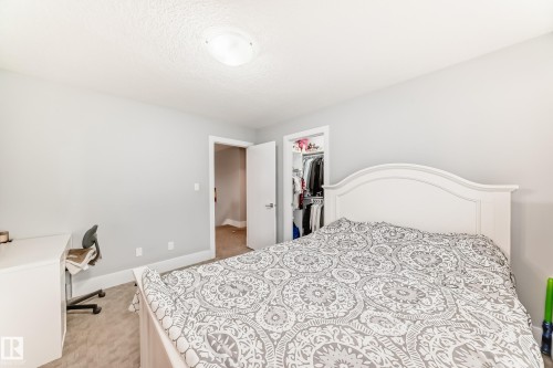 Carpeted room featuring light gray walls, a white trimmed doorway, and a ceiling-mounted light fixture - 69 Caragana Way, Fort Saskatchewan, AB 