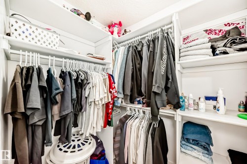 Custom-designed closet system featuring white shelving and hanging rods - 69 Caragana Way, Fort Saskatchewan, AB 