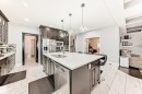 Kitchen featuring a large central island with a sink, white countertop, and pendant lighting - 69 Caragana Way, Fort Saskatchewan, AB 
