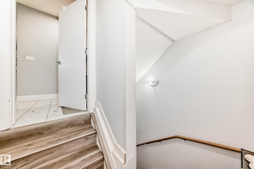 Staircase featuring wood-finish treads and a light wood handrail - 69 Caragana Way, Fort Saskatchewan, AB 