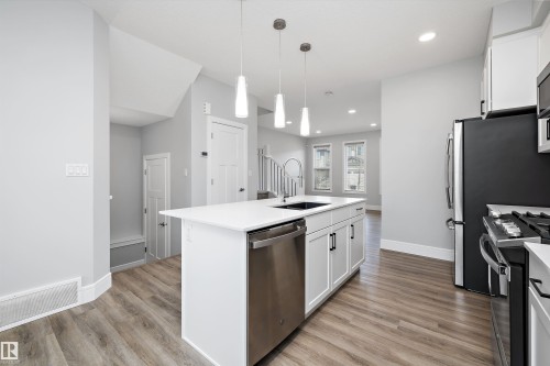 Modern kitchen featuring a central island with a built-in sink and stainless steel dishwasher - 4235 Chichak Close, Edmonton, AB - Indoor Photo Showing Kitchen With Upgraded Kitchen