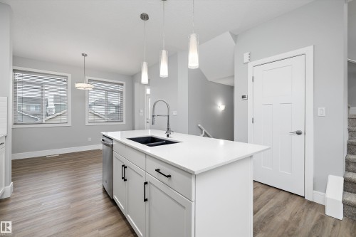 Kitchen island featuring a single-basin sink, gooseneck faucet, and pendant lighting - 4235 Chichak Close, Edmonton, AB - Indoor Photo Showing Kitchen With Double Sink