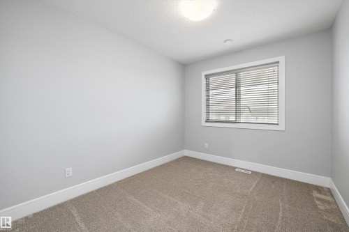Room featuring light gray walls, neutral-toned carpet, white baseboards, and a window with white blinds - 4235 Chichak Close, Edmonton, AB - Indoor Photo Showing Other Room
