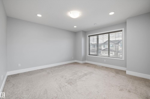 Spacious room featuring neutral carpeting, light gray wall paint, and white trim - 4235 Chichak Close, Edmonton, AB - Indoor Photo Showing Other Room