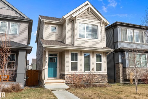Two-story residence featuring light-colored siding with stone accents on the lower facade - 4235 Chichak Close, Edmonton, AB - Outdoor With Facade
