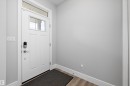 Entryway featuring a white paneled door with integrated window, a transom window, and a smart lock - 4235 Chichak Close, Edmonton, AB  - Indoor Photo Showing Other Room 