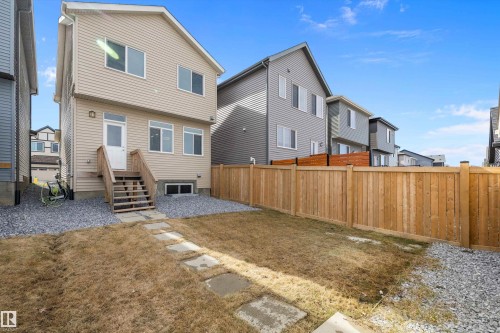 Rear exterior of a two-story residence featuring light-colored horizontal siding and multiple windows - 4235 Chichak Close, Edmonton, AB - Outdoor