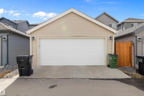 Single-car garage with beige horizontal siding and a white panel door - 4235 Chichak Close, Edmonton, AB - Outdoor With Exterior