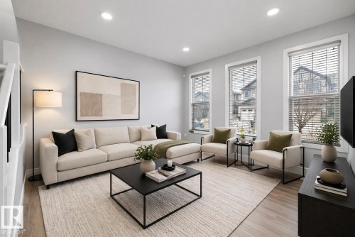 Living area featuring light gray walls, recessed lighting, and wood-finish flooring - 4235 Chichak Close, Edmonton, AB - Indoor Photo Showing Living Room