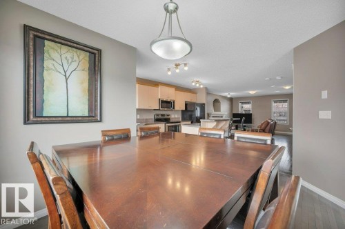 Dining area featuring wood-finish flooring and a central chandelier - 12063 19 Avenue, Edmonton, AB - Indoor Photo Showing Dining Room