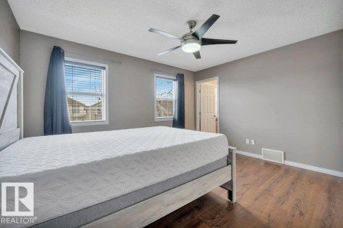 Interior space featuring wood-finish flooring, light gray wall paint, and a ceiling fan with integrated lighting - 12063 19 Avenue, Edmonton, AB - Indoor Photo Showing Bedroom