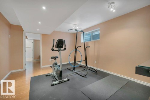 Versatile room featuring recessed lighting, a window with horizontal blinds, light wood-finish flooring, and a portion with black rubber flooring - 12063 19 Avenue, Edmonton, AB - Indoor Photo Showing Gym Room