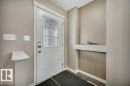 Entryway featuring a decorative frosted glass door with grid details, light neutral wall paint, and white baseboards - 12063 19 Avenue, Edmonton, AB  - Indoor Photo Showing Other Room 