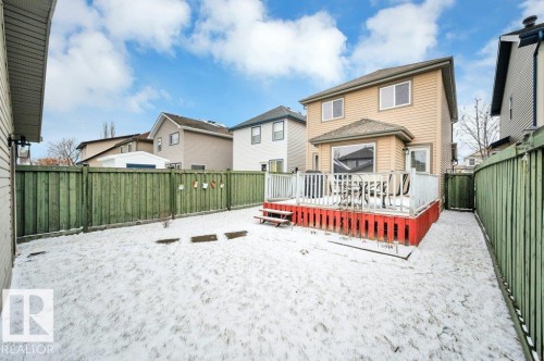 Rear exterior featuring a spacious wooden deck with white railings and a red base - 12063 19 Avenue, Edmonton, AB - Outdoor With Deck Patio Veranda With Exterior