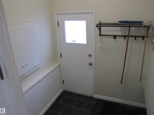 Entryway featuring dark rectangular floor tiles and a white door with a frosted glass pane - 7135 87 Street, Edmonton, AB - Indoor Photo Showing Other Room