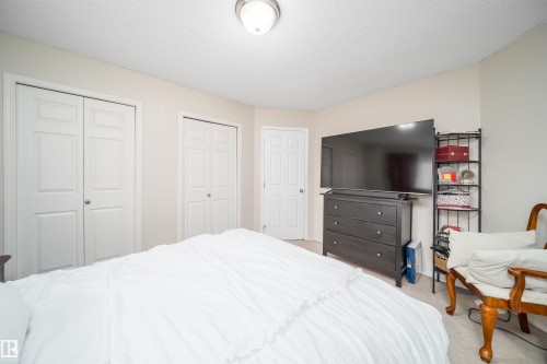 Neutral-toned room featuring a single overhead light fixture and light-colored walls - 50 14603 Miller Boulevard, Edmonton, AB - Indoor Photo Showing Bedroom
