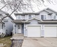 Two-story residence featuring light blue siding, a double garage with white doors, and a concrete driveway - 50 14603 Miller Boulevard, Edmonton, AB  - Outdoor With Facade 