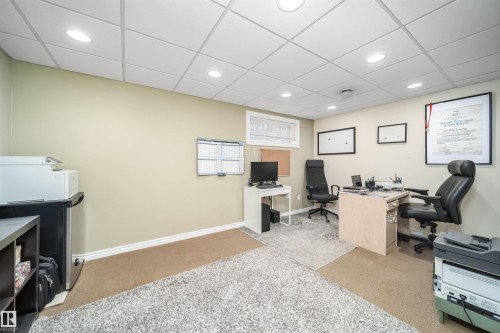 Recessed lighting illuminates this versatile room, featuring a dropped ceiling and a mix of carpet and area rug flooring - 50 14603 Miller Boulevard, Edmonton, AB - Indoor Photo Showing Office