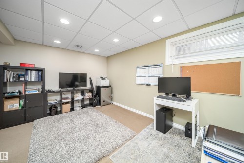 Versatile room featuring recessed lighting, a drop ceiling, and a window with blinds - 50 14603 Miller Boulevard, Edmonton, AB - Indoor