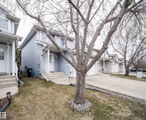 Exterior featuring light blue vinyl siding and a white front door with a glass insert - 50 14603 Miller Boulevard, Edmonton, AB - Outdoor