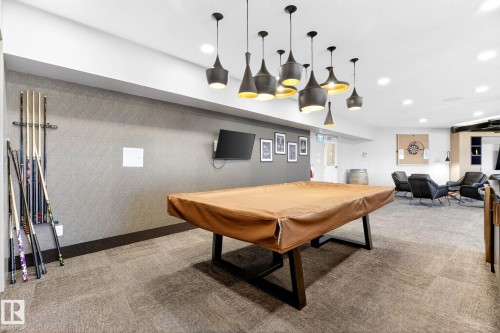 Recreation room featuring a contemporary billiard table, textured accent wall, recessed lighting, and a collection of pendant light fixtures - 520 7463 May Common, Edmonton, AB - Indoor Photo Showing Other Room