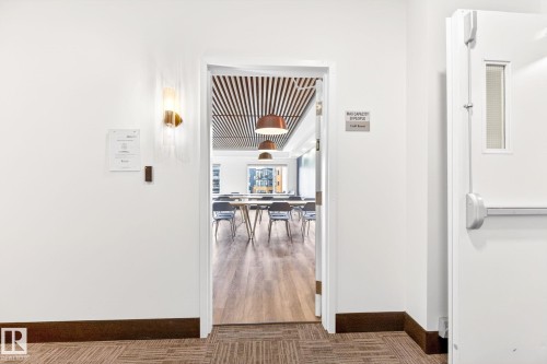 Interior space with wood-finish flooring and a distinctive slatted wood ceiling - 520 7463 May Common, Edmonton, AB - Indoor Photo Showing Other Room